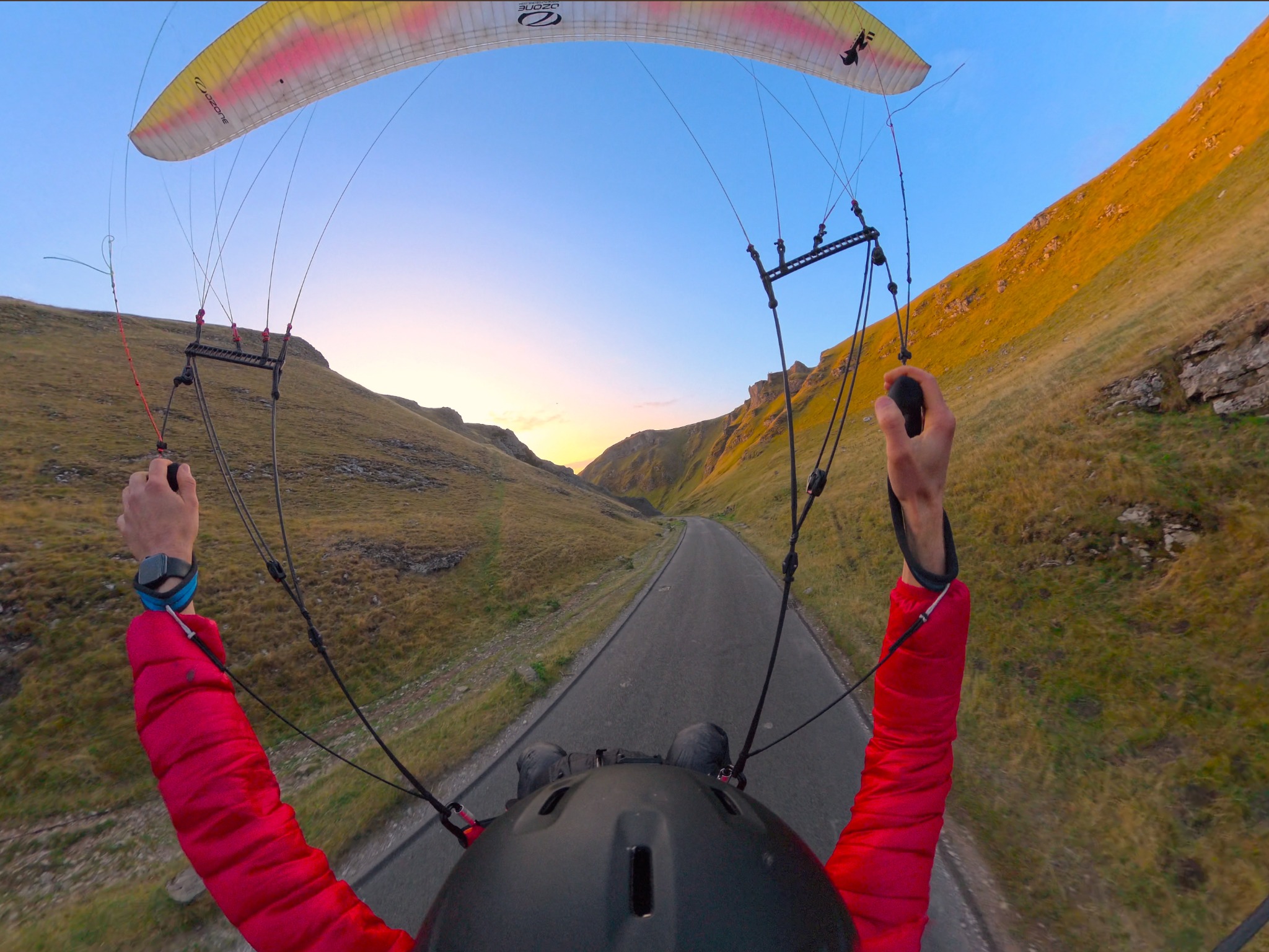 Chey flying beneath his wing through Winnats Pass at sunset